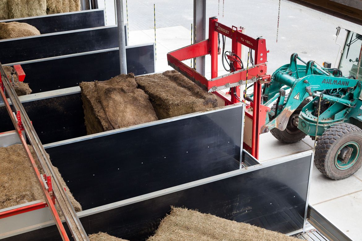 An-Trioliet-robotic-feeder-consists-of-a-feed-storage-with-feed-floors
